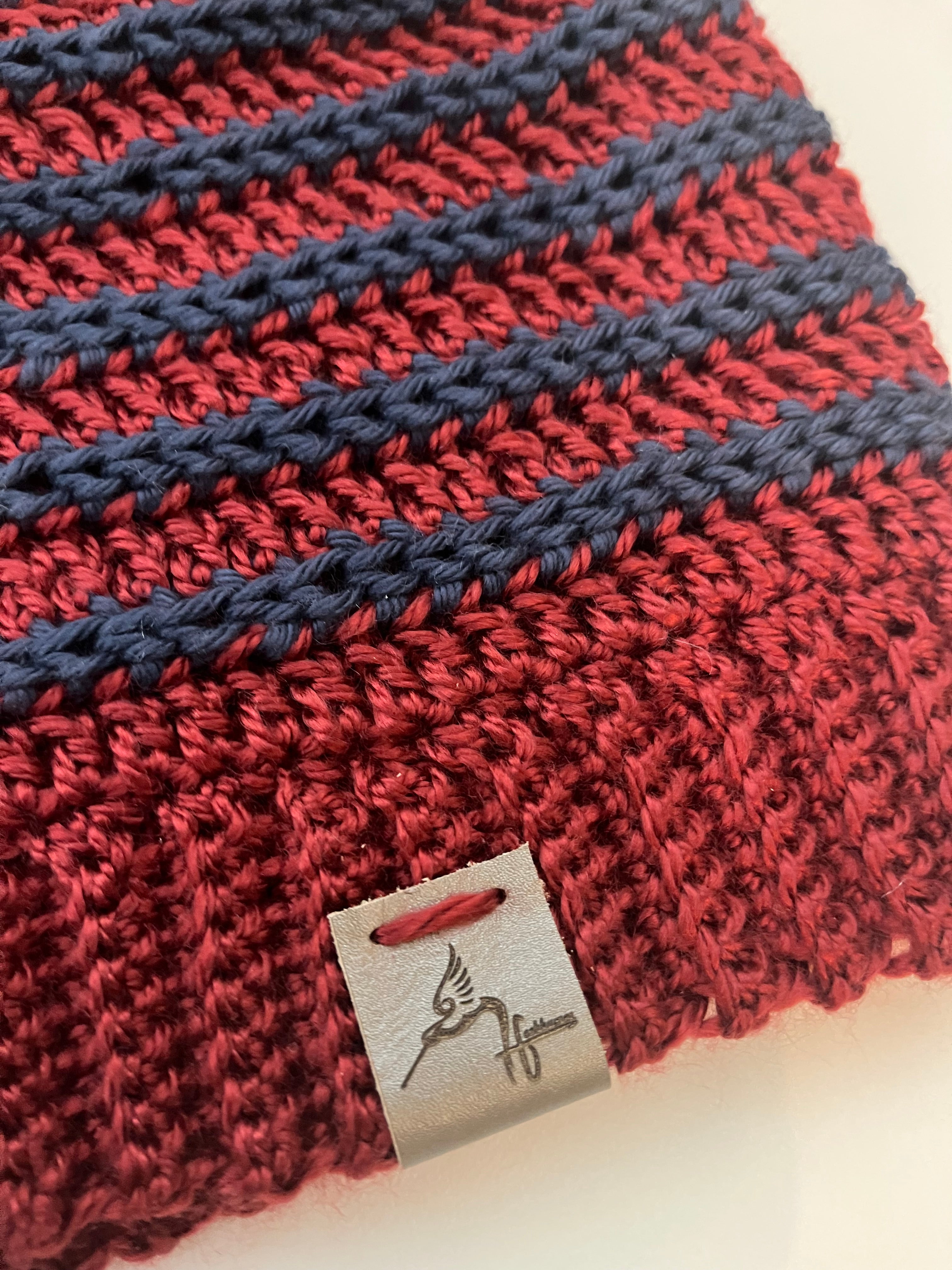 Close-up of a red and navy knitted fabric with a brand tag.