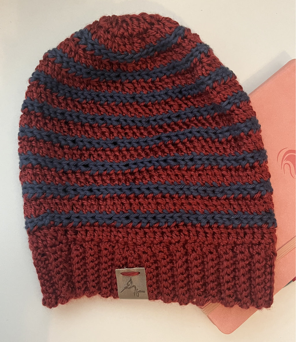 Knitted beanie with red and blue stripes on a white background